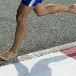 A closeup of a runners feet while barefoot running on a track